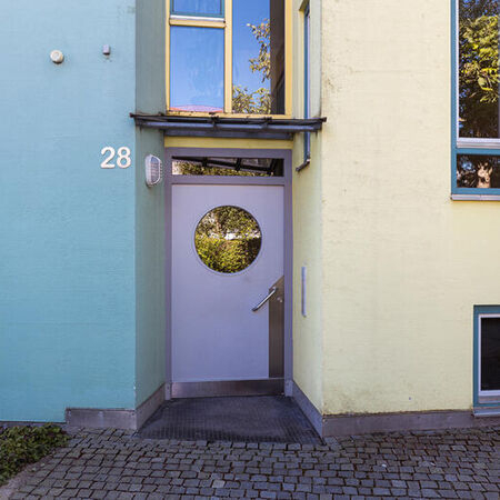 Einladender Hauseingang einer Erdinger Wohnanlage mit runder Türverglasung